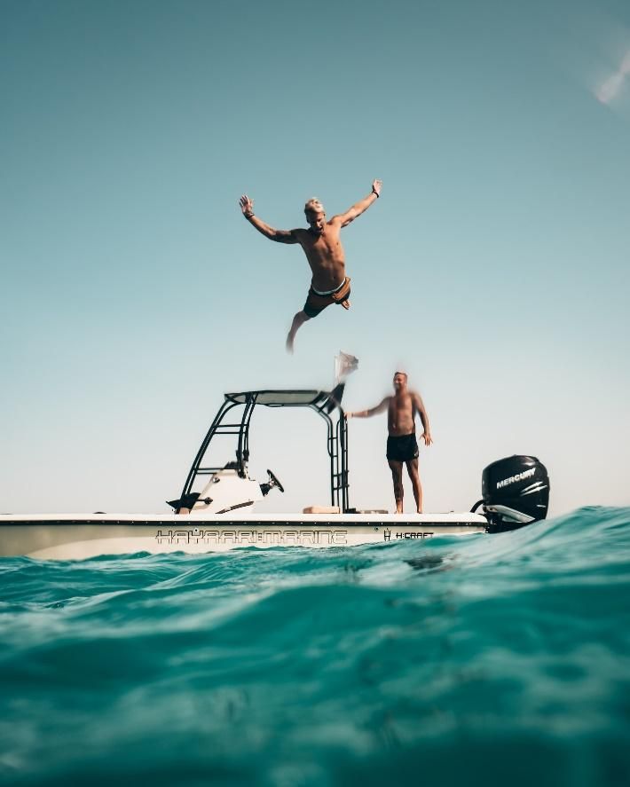 Un homme plonge dans l'eau depuis le bateau.