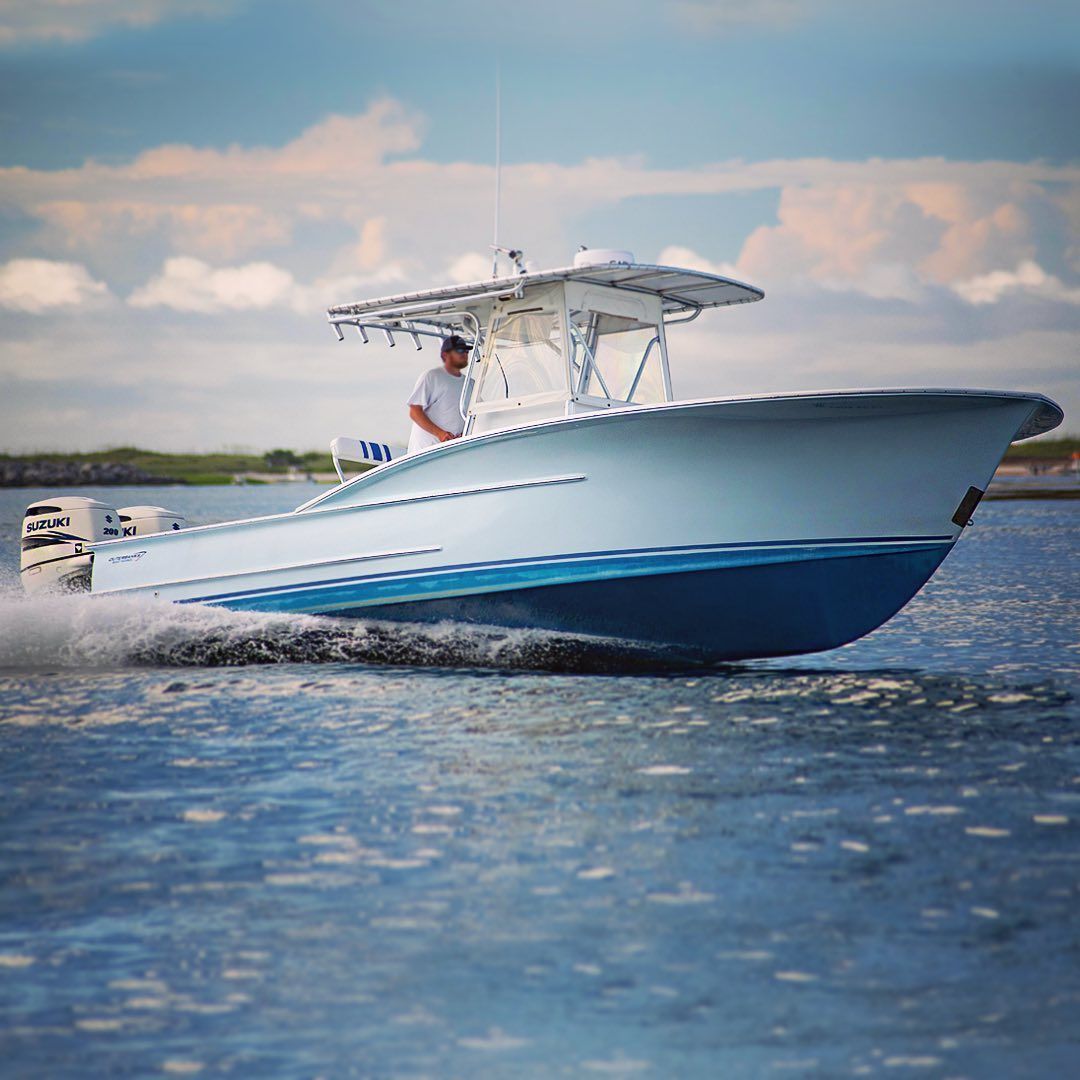 Vue latérale d'un homme conduisant un yacht sur l'eau.