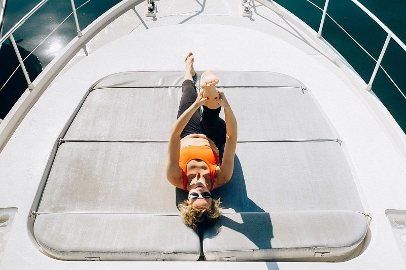 Une femme fait du yoga sur le pont d'un bateau.