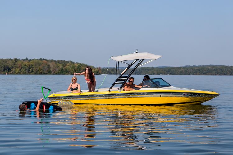 femme lançant une corde de remorquage à un wakeboarder