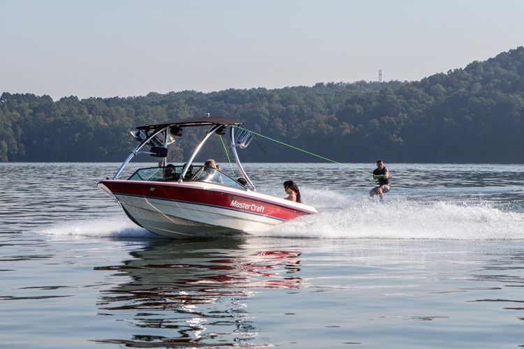 homme faisant du wakeboard derrière un bateau