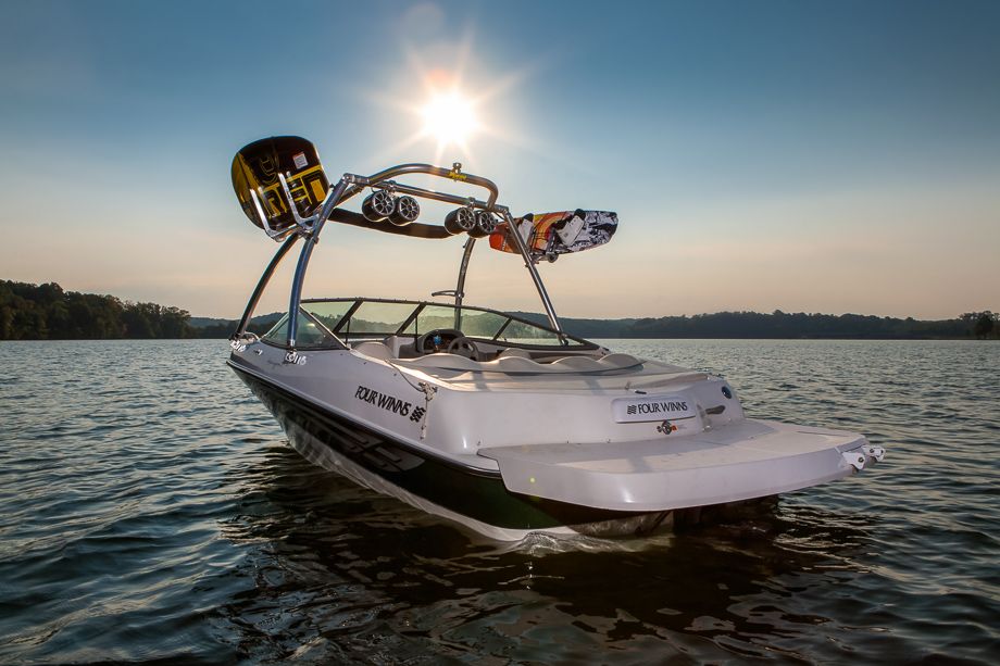 bateau wakeboard avec tours, racks et planches sur l'eau