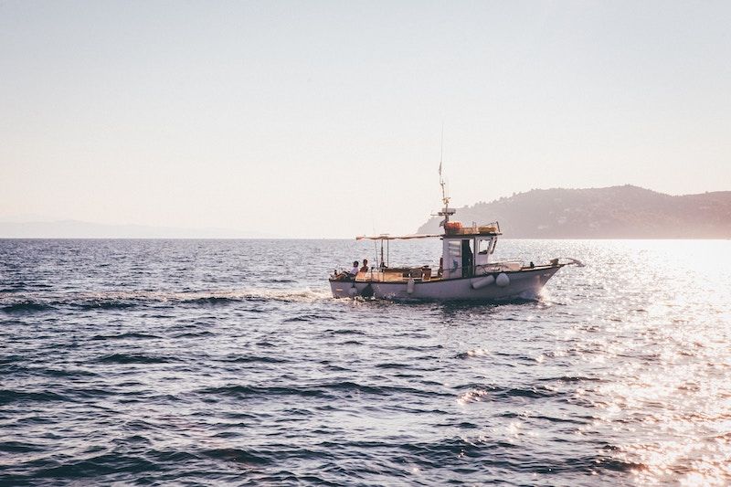 Un petit bateau de pêche sur l'océan sous le soleil du soir. 