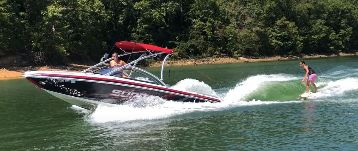 un homme fait du wakesurf derrière un bateau supra avec un wake shaper surfmode