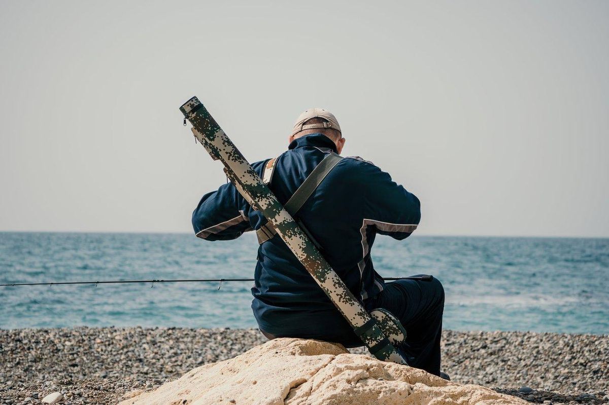 Fisherman using touchscreen sonar on Lowrance Elite FS 7 during coastal fishing session.