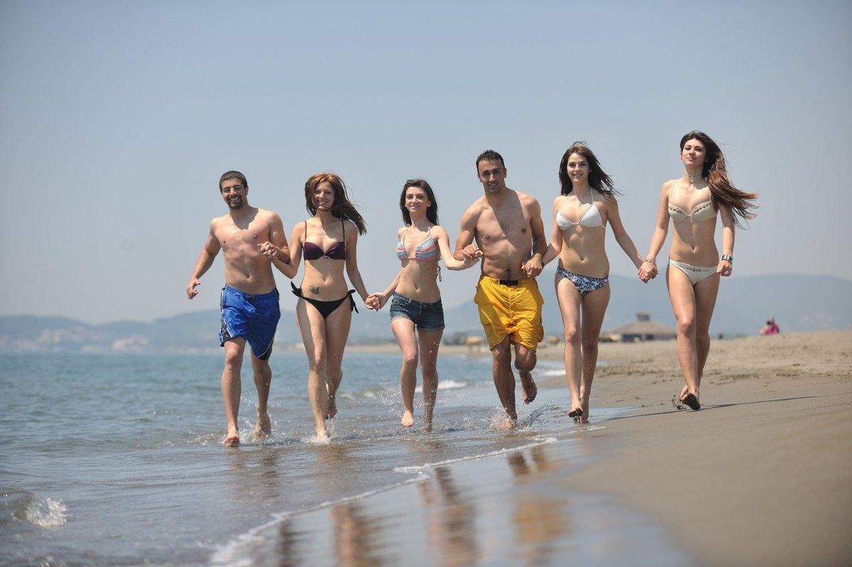Groupe de personnes en longe-côte sur la plage, pratiquant la marche aquatique pour tous niveaux.