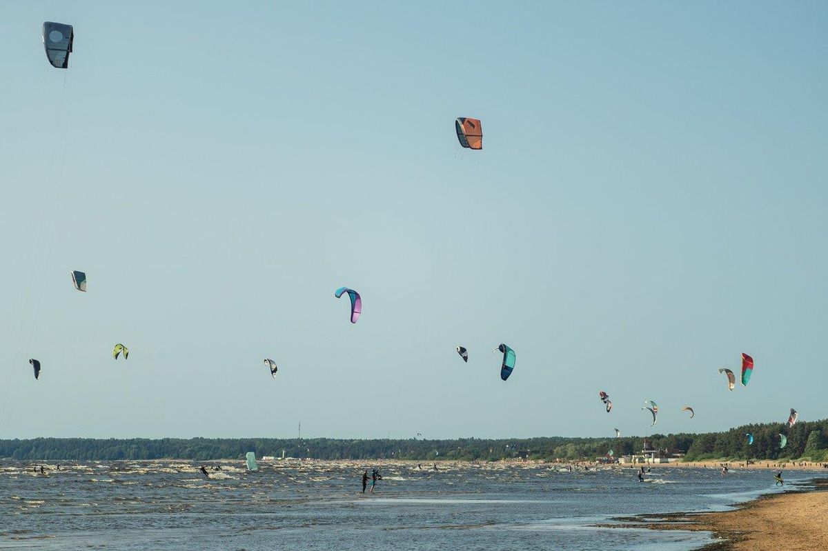 Groupe de stagiaires de kitesurfing en leçon collective sur la côte Basque, encadrés par un moniteur.