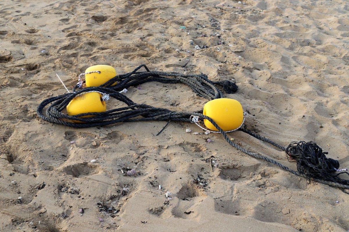 Pêcheur ajustant un montage flotteur pour la pêche au flotteur en mer, matériel visible sur la ligne.