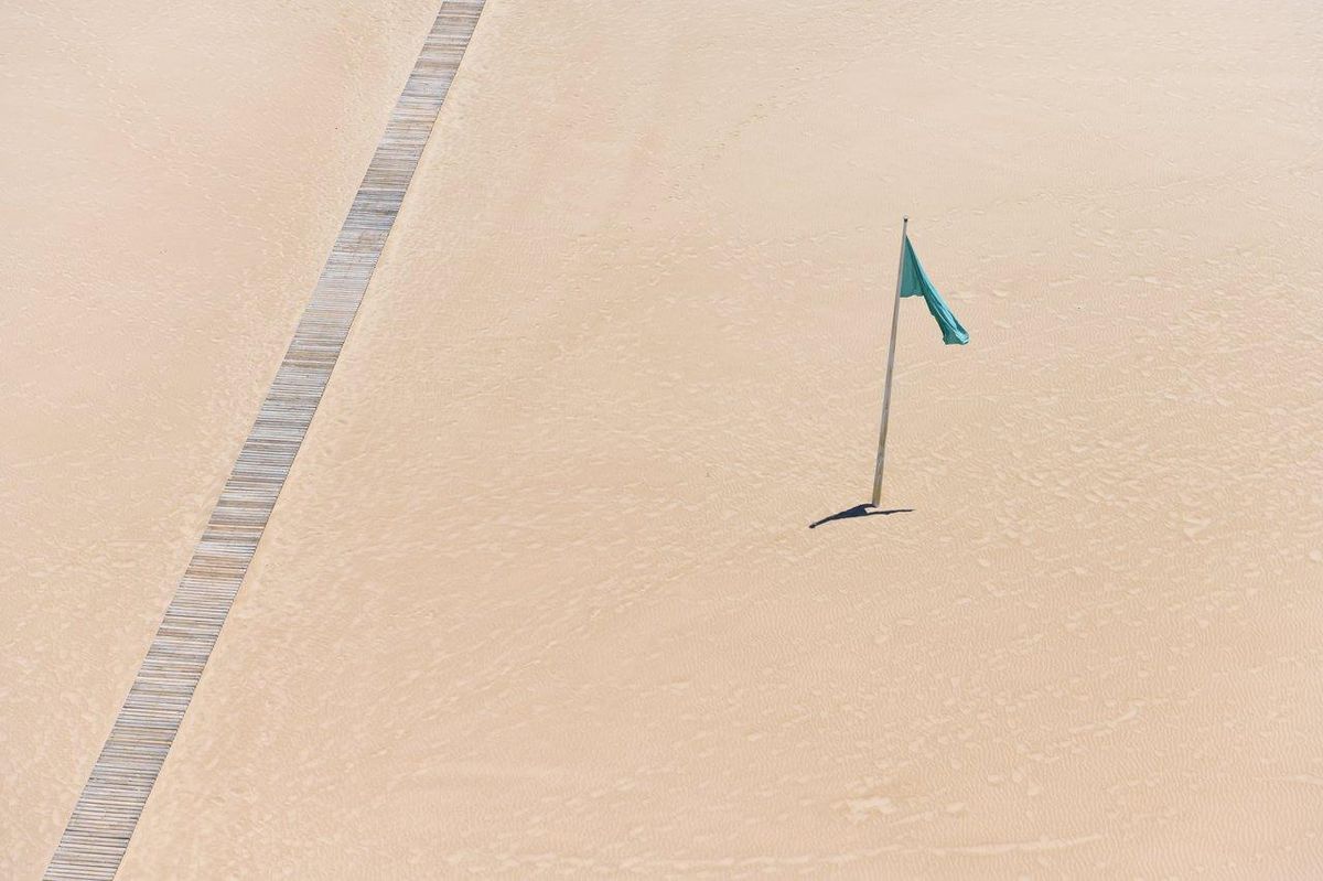 Plage française avec pavillon bleu, idéale pour les sports nautiques et la sécurité assurée.