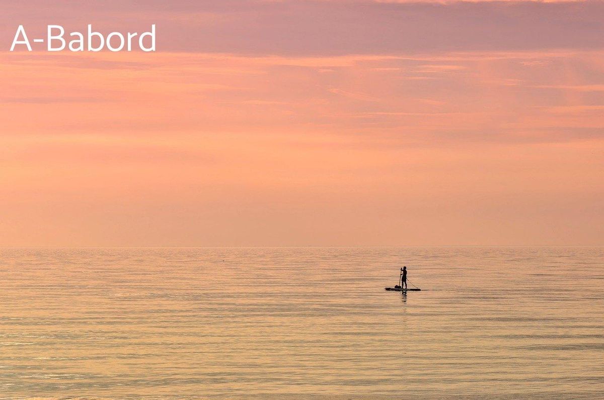 Silhouette d'un pagayeur au crépuscule: une harmonie pour vos compétitions de paddle locales.