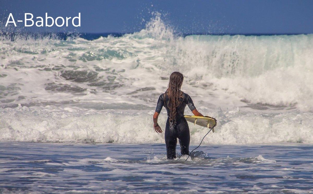 Surfeuse au bord des vagues, cherche son rythme avant de pagayer vers l'horizon déchaîné.