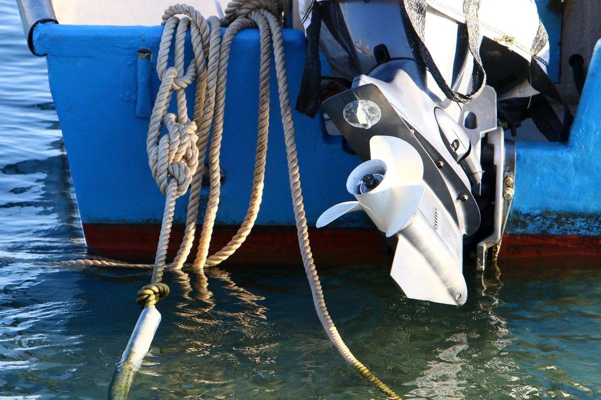 Technicien nautique réalisant un contrôle moteur de bateau pour assurer une maintenance marine efficace.