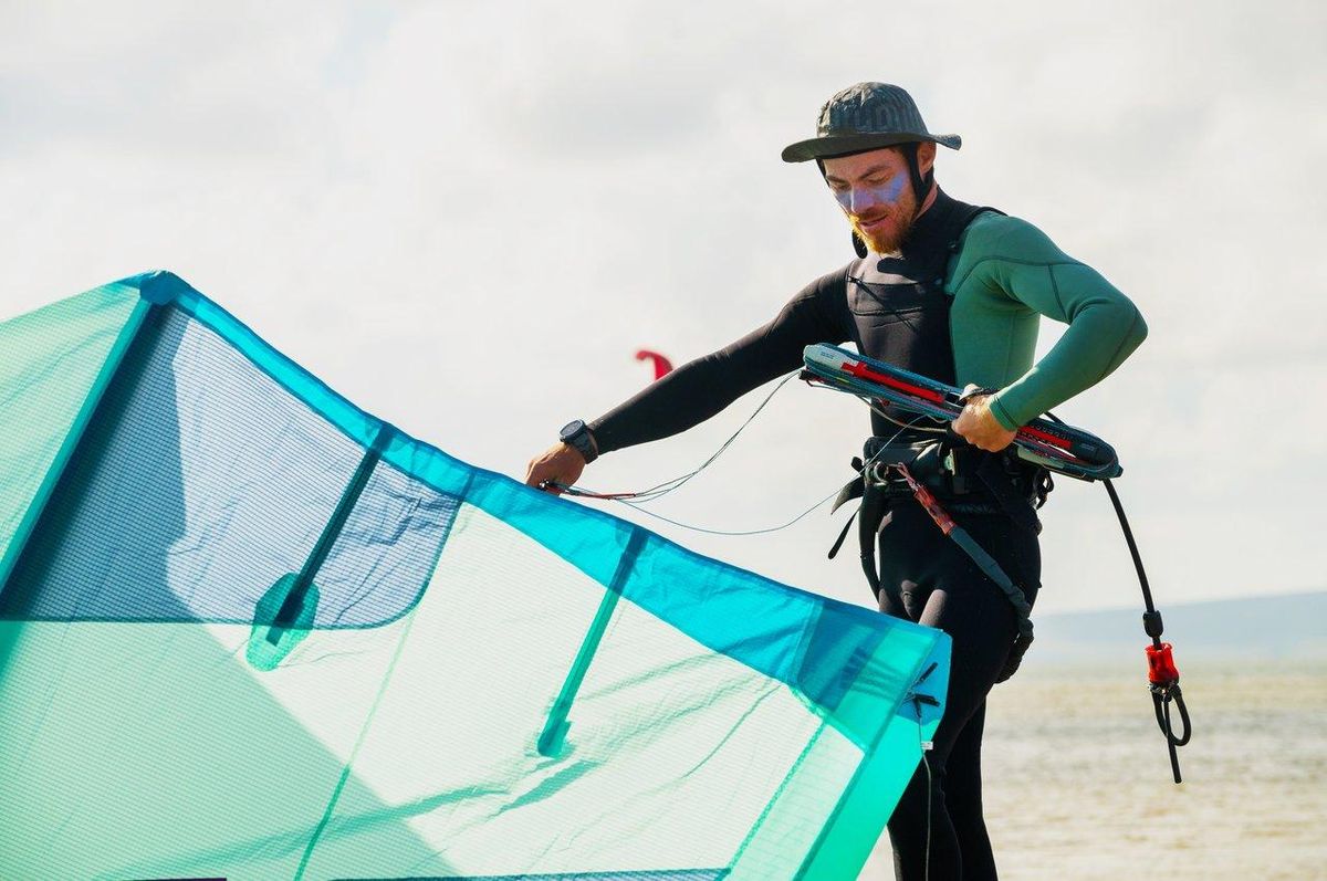 Un kite surfer vérifie les prévisions météo sur sa tablette avant de profiter des conditions idéales en mer.