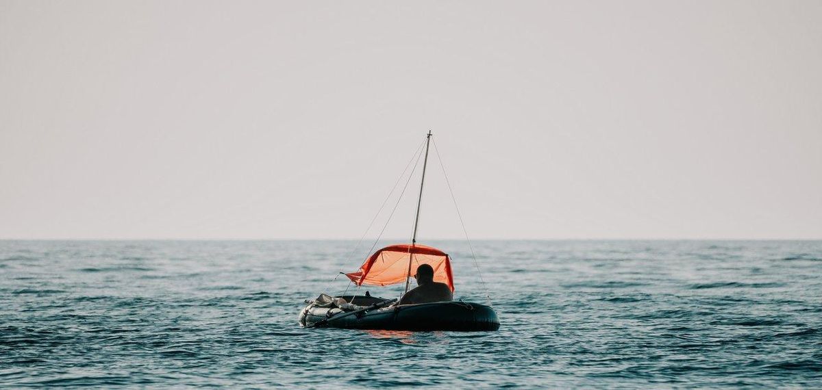 Un pêcheur debout sur un rigid inflatable fishing boat, profitant d'une sortie en mer au coucher du soleil.