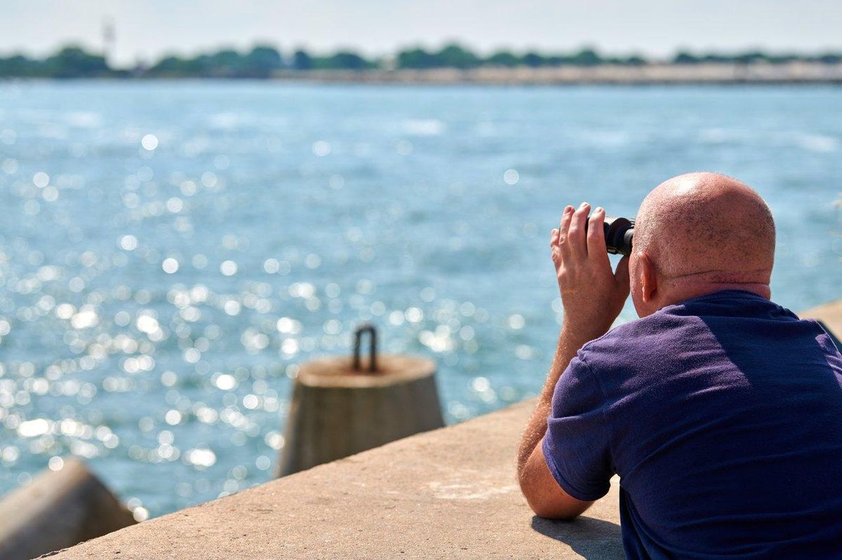 Un pêcheur expérimenté observe attentivement la mer pour anticiper l’impact des marées sur la pêche en mer.