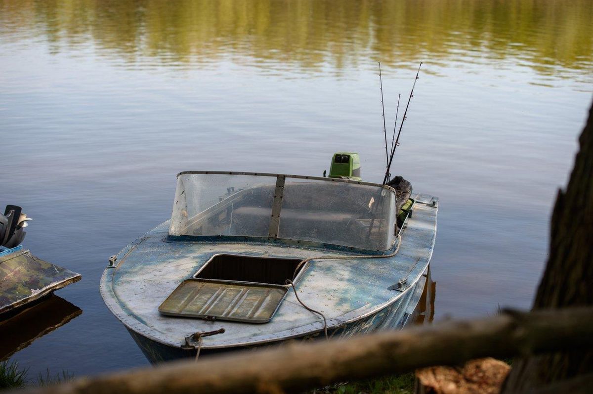 Une embarcation de pêche au silure guidée sur un lac paisible, idéale pour une initiation en toute tranquillité.