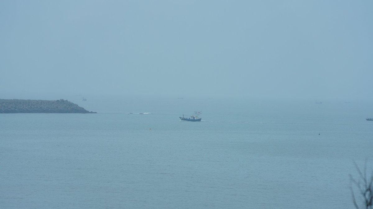 Une pêche en mer sereine avec une embarcation sous un ciel nuageux et une légère houle, signal météo à surveiller.
