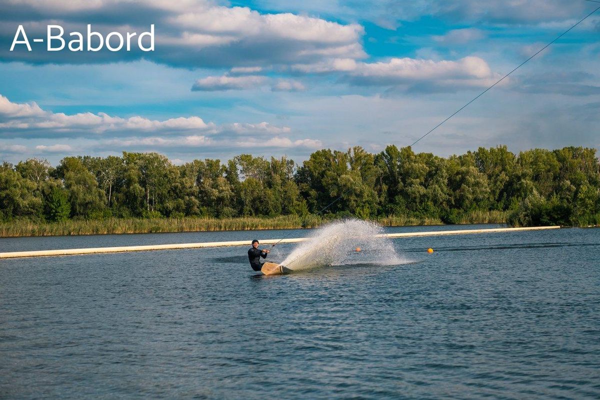 Wakeboard en pleine action sous un ciel bleu, ambiance idéale pour Réunion en hiver.
