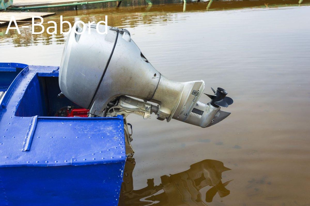 Zoom sur un outboard motor closeup installé sur un bateau de pêche en aluminium bleu.