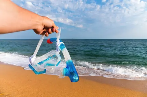 Masque de snorkeling posé sur une plage au coucher du soleil