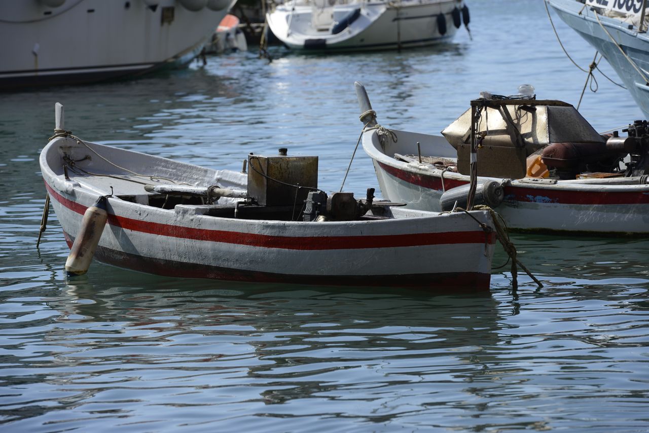 Bateau de plaisance en traîne côtière avec canne légère et leurre minnow en Méditerranée au coucher du soleil.
