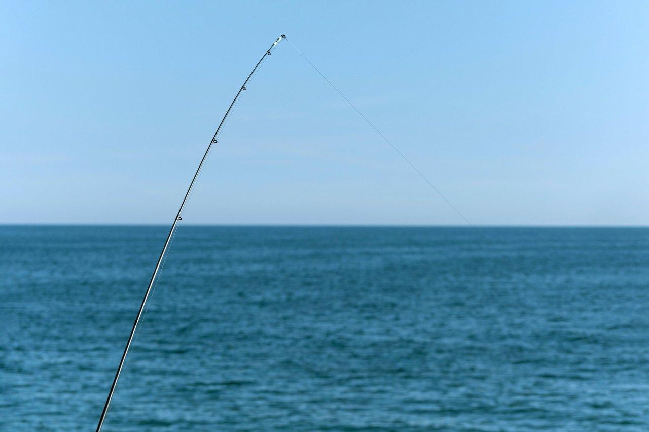 Canne télescopique Decathlon Seacoast-500 prête à pêcher en duo en bord de mer, idéale pour une expérience relaxante.