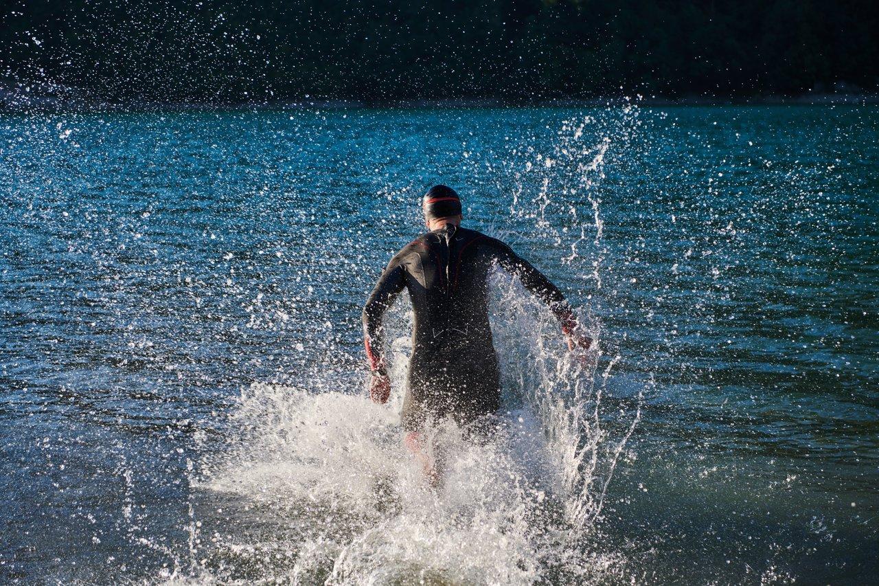 Départ de la natation lors d'un triathlon, avec athlètes prêts à plonger dans le lac.