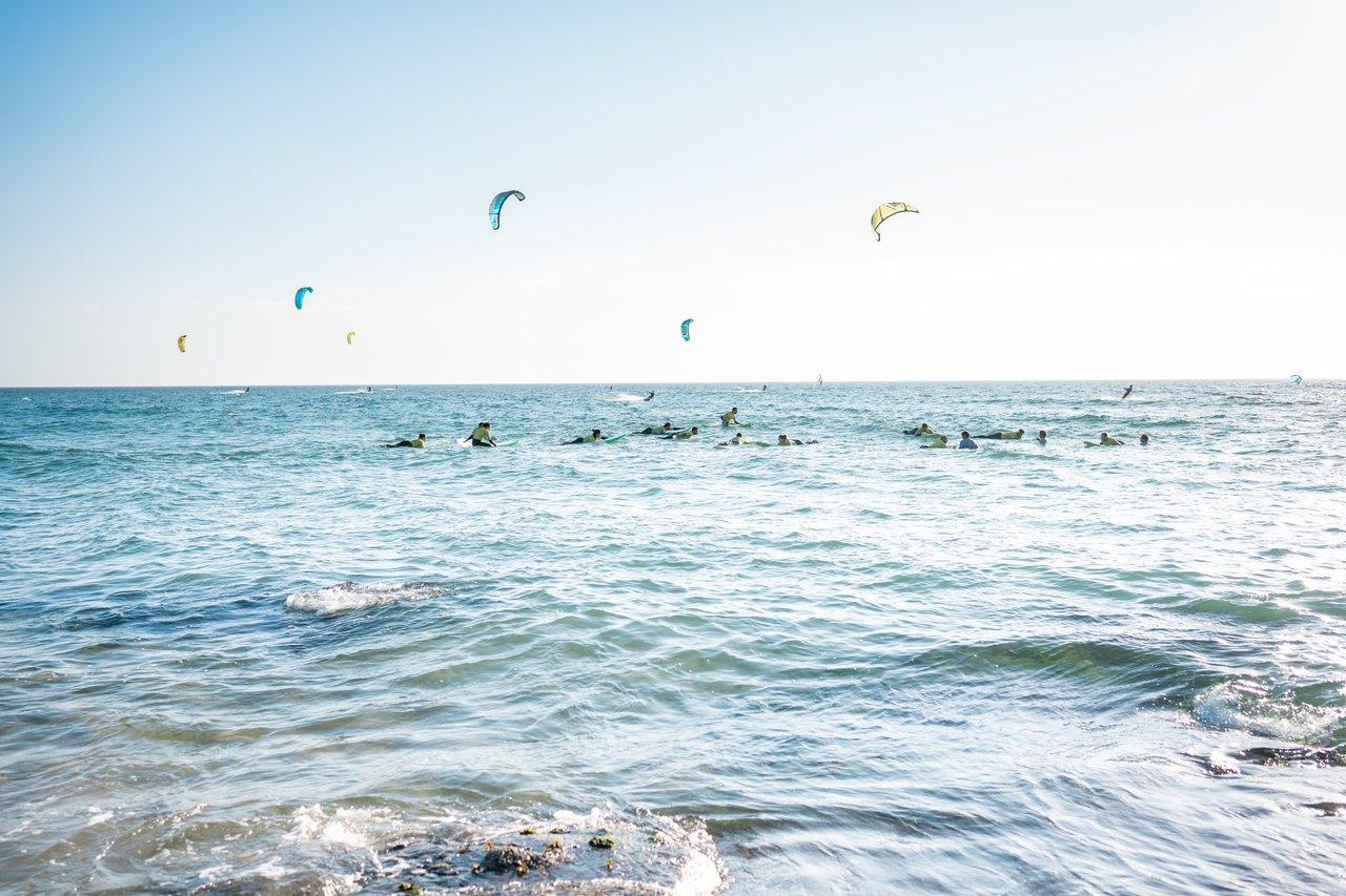 Groupe de débutants en kitesurf lors d'une leçon encadrée sur un plan d’eau calme, parfait pour progresser.
