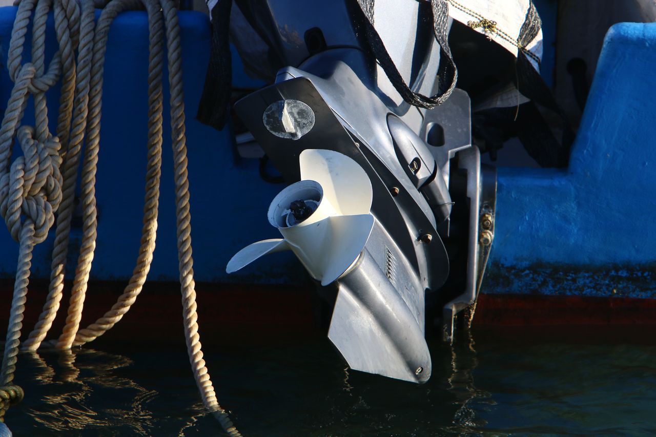 Hors-bord Yamaha F25 sur cale, embase démontée et outils de diagnostic pour entretien moteur bateau.