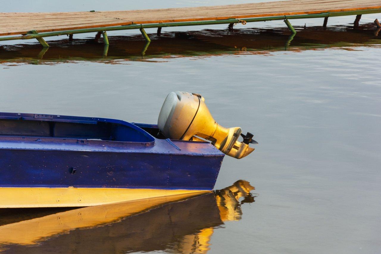 Moteur hors-bord électrique installé sur un bateau de pêche sur un plan d’eau intérieur.