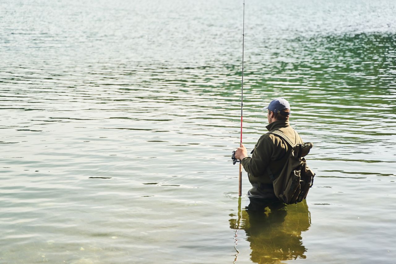 Pêcheur immobile en waders néoprène 5 mm sur une berge froide pour la pêche hivernale.